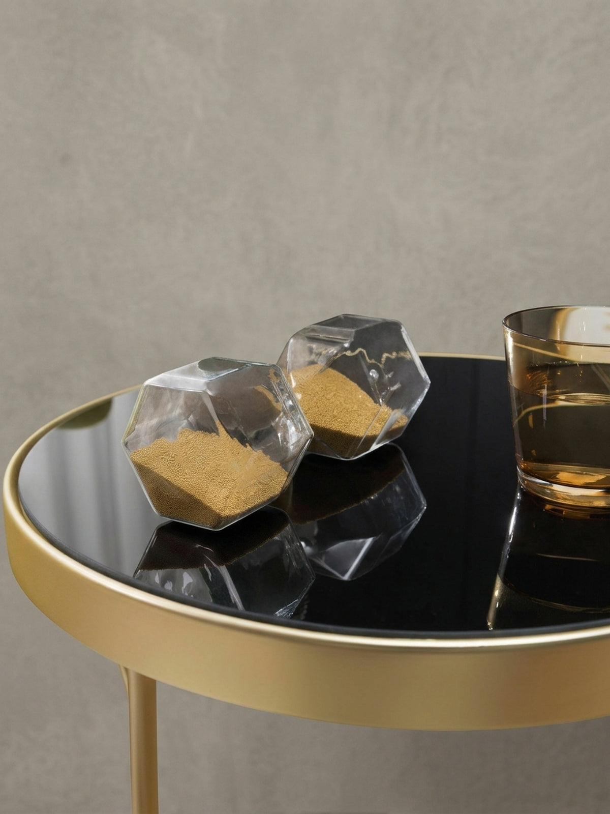 Geometrischer Couchtisch PARMA aus leicht erhöhter Perspektive. Die Kombination aus schwarzem Spiegelglas und dem glamourösen Goldrahmen bringt luxuriöses Flair ins heimische Wohnzimmer.