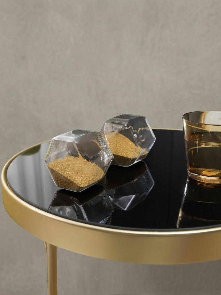 Geometrischer Couchtisch PARMA aus leicht erhöhter Perspektive. Die Kombination aus schwarzem Spiegelglas und dem glamourösen Goldrahmen bringt luxuriöses Flair ins heimische Wohnzimmer._