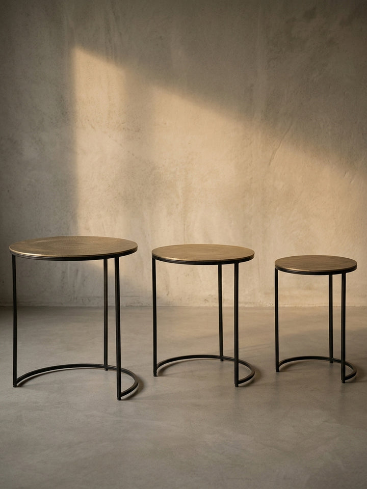 Freigestellte Ansicht des kompletten Beistelltisch-Sets in Gold und Schwarz, das die drei unterschiedlichen Größen deutlich zeigt._