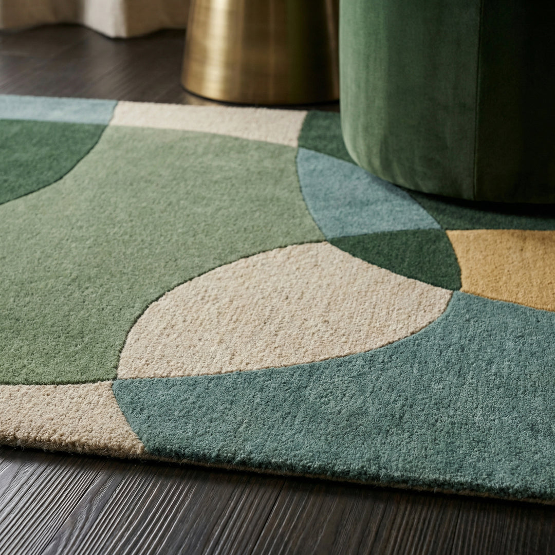Draufsicht und Detailaufnahme eines abstrakten Wollteppichs mit grünen und blauen Formen auf beigem Grund_