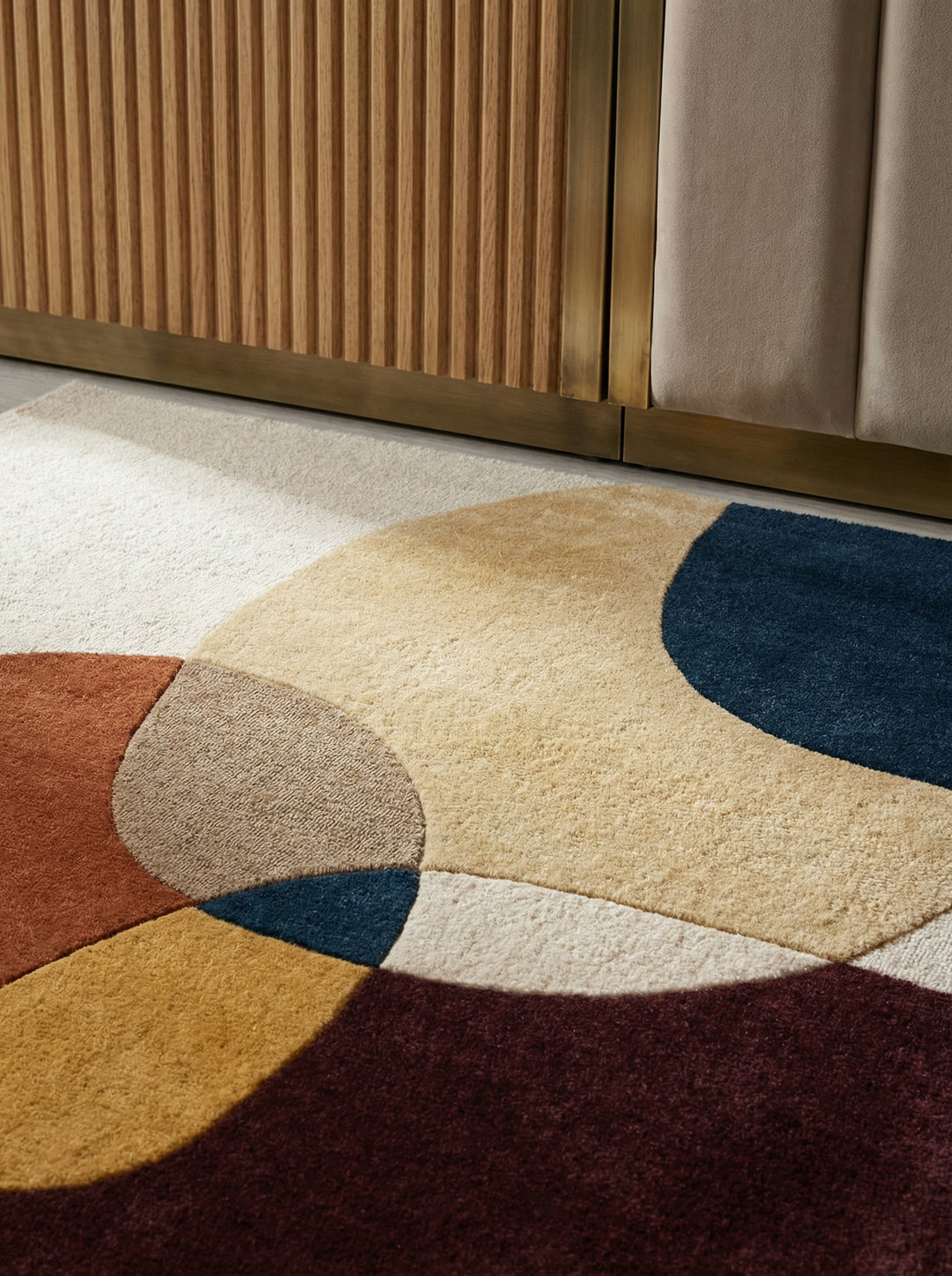 Ein moderner Teppich mit großen, bunten Kreisen und Formen liegt auf einem hellen Holzboden_