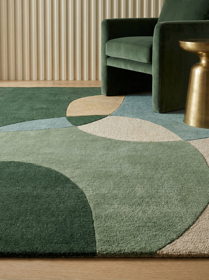 Draufsicht und Detailaufnahme eines abstrakten Wollteppichs mit grünen und blauen Formen auf beigem Grund_