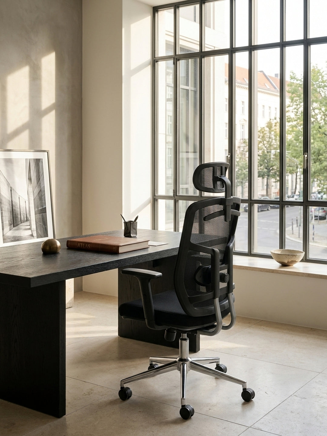 Die Nahaufnahme zeigt die feine, atmungsaktive Netzstruktur des schwarzen Mesh-Gewebes an der Rückenlehne des Schreibtischsessels, ideal für lange Arbeitstage im Büro._