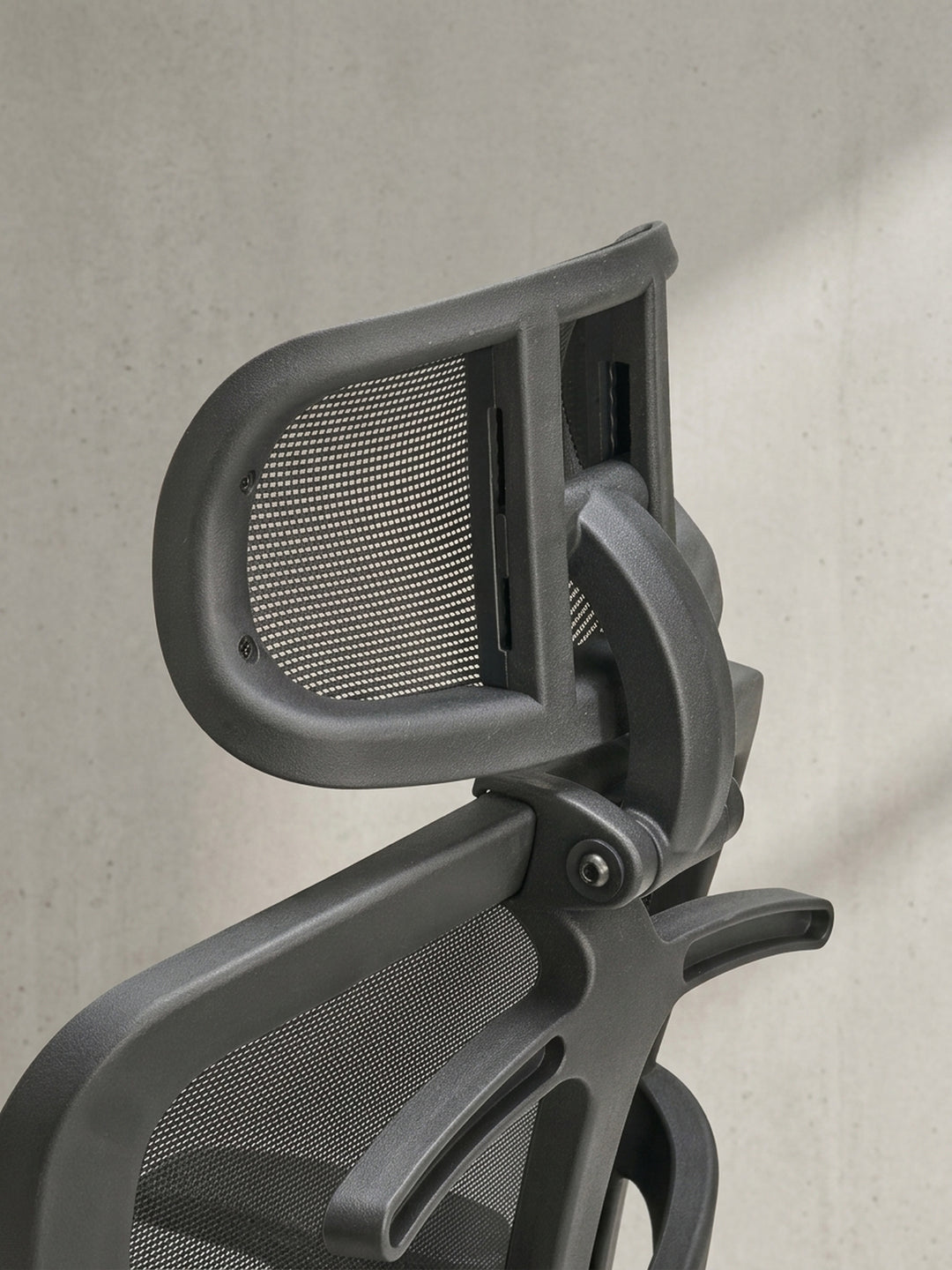 Ein Blick auf den Hebel für die Höhenverstellung und die Gasdruckfeder verdeutlicht die robusten Bedienelemente des ergonomischen schwarzen Bürodrehstuhls._