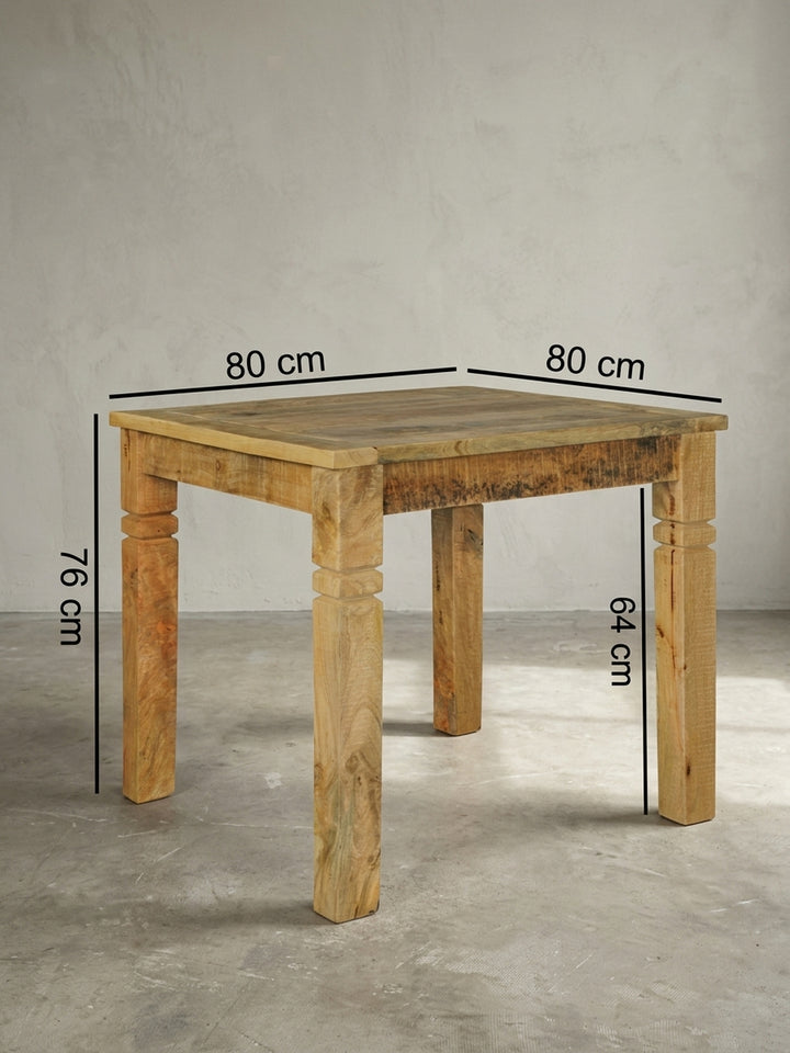 Detailansicht der Konstruktion des massiven Holztisches. Die Verbindung der quadratischen Tischplatte mit den kräftigen Beinen des braunen Küchentisches zeugt von hoher Stabilität._
