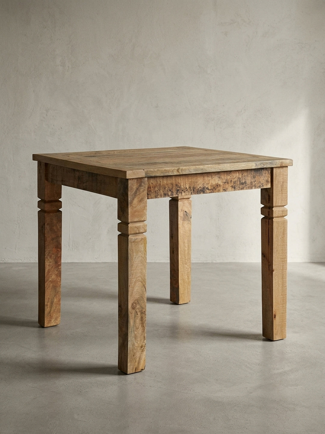 Rustikaler Küchentisch aus Mangoholz frontal freigestellt. Der quadratische Massivholztisch 80x80x76 cm besticht durch massive Beine und ein klassisches Landhaus Design in Braun._