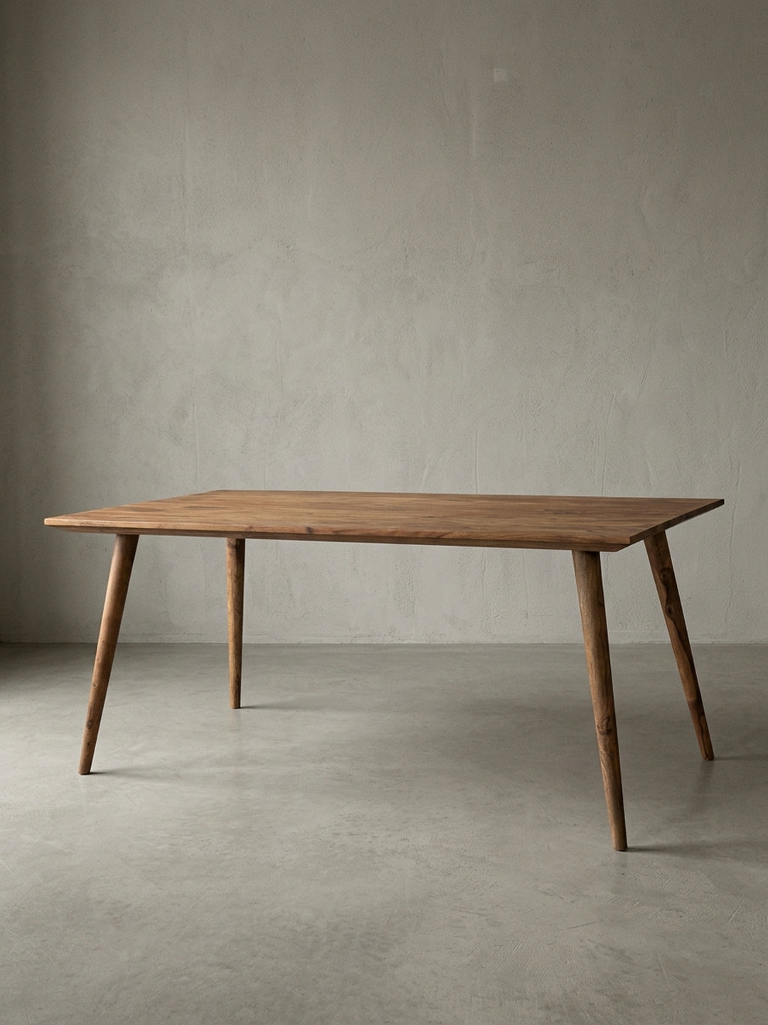 Esstisch aus warmem Sheesham-Massivholz mit markanter Maserung auf neutralem Betonhintergrund Frontalansicht 80x180x76 cm_