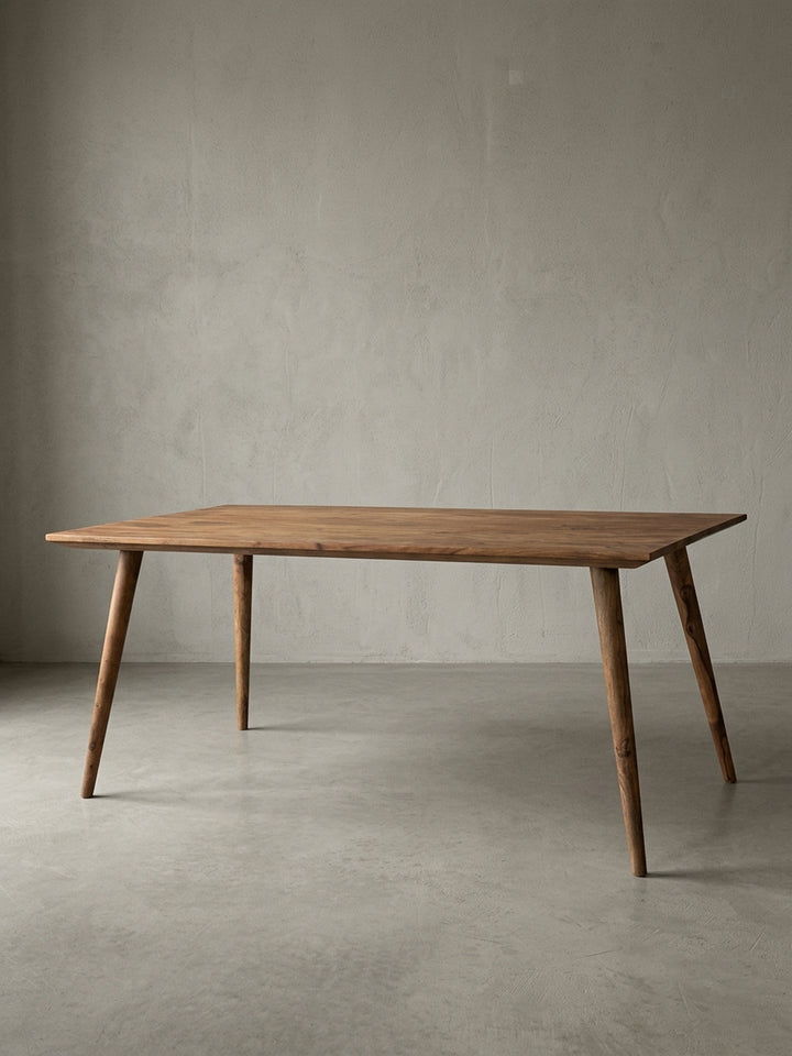 Esstisch aus warmem Sheesham-Massivholz mit markanter Maserung auf neutralem Betonhintergrund Frontalansicht 80x180x76 cm_