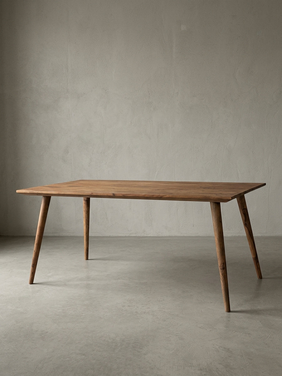 Esstisch aus warmem Sheesham-Massivholz mit markanter Maserung auf neutralem Betonhintergrund Frontalansicht 80x180x76 cm_
