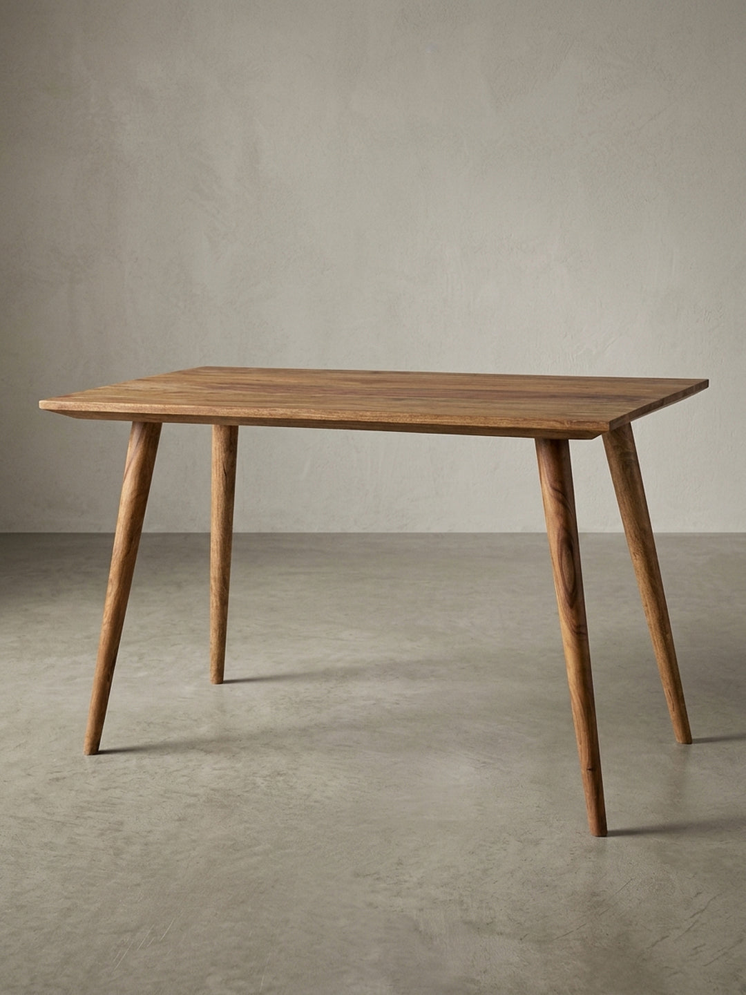 Esstisch aus warmem Sheesham-Massivholz mit markanter Maserung auf neutralem Betonhintergrund Frontalansicht 60x120x76 cm_