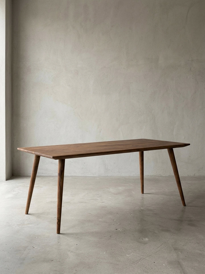 Esstisch aus warmem Sheesham-Massivholz mit markanter Maserung auf neutralem Betonhintergrund Frontalansicht 80x180x76 cm_