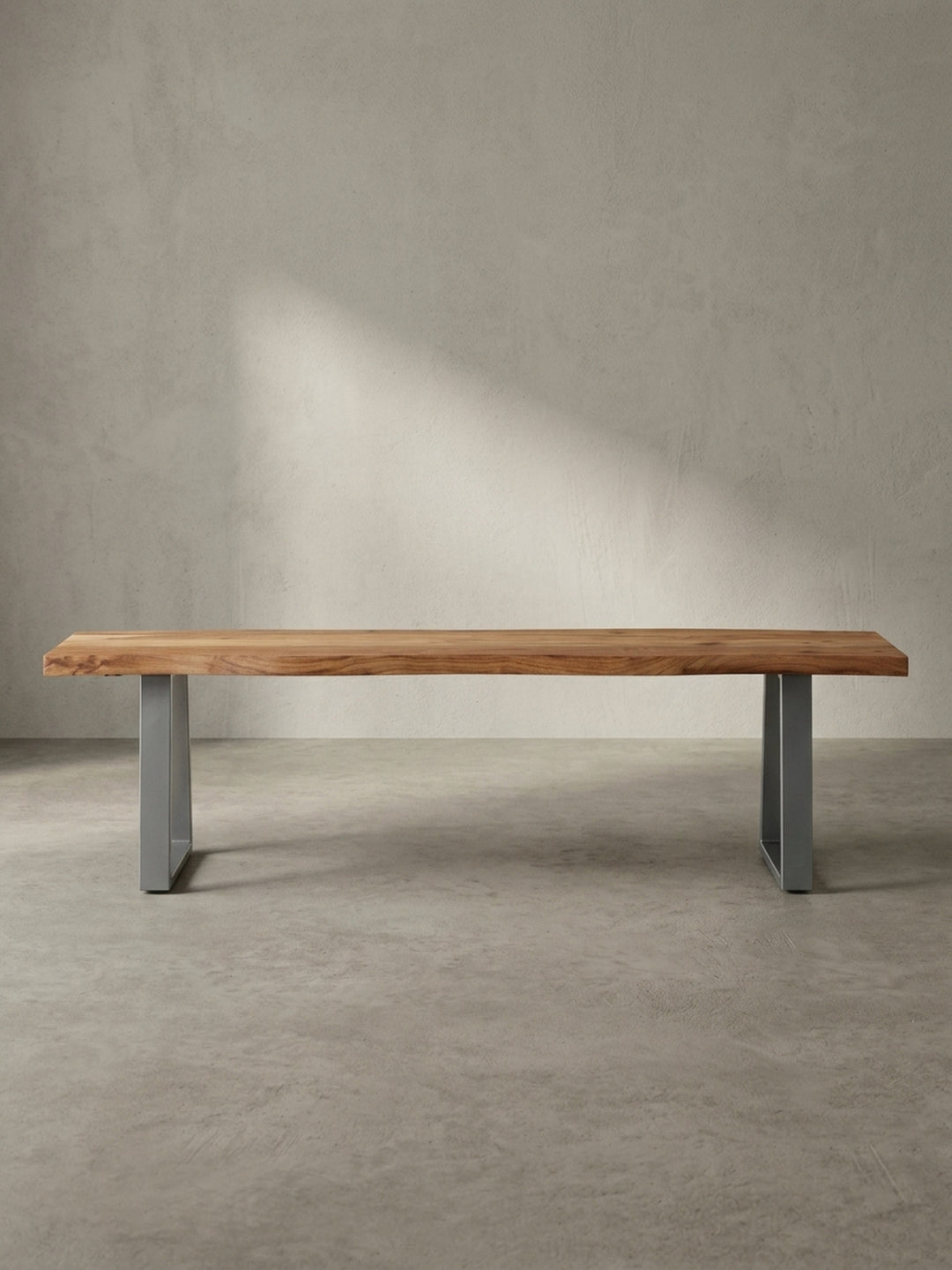 Schrägansicht der modernen Küchenbank aus massivem Akazienholz, die die Tiefe der 3,5 cm starken Sitzplatte und das industrielle Design der Metallkufen zeigt._