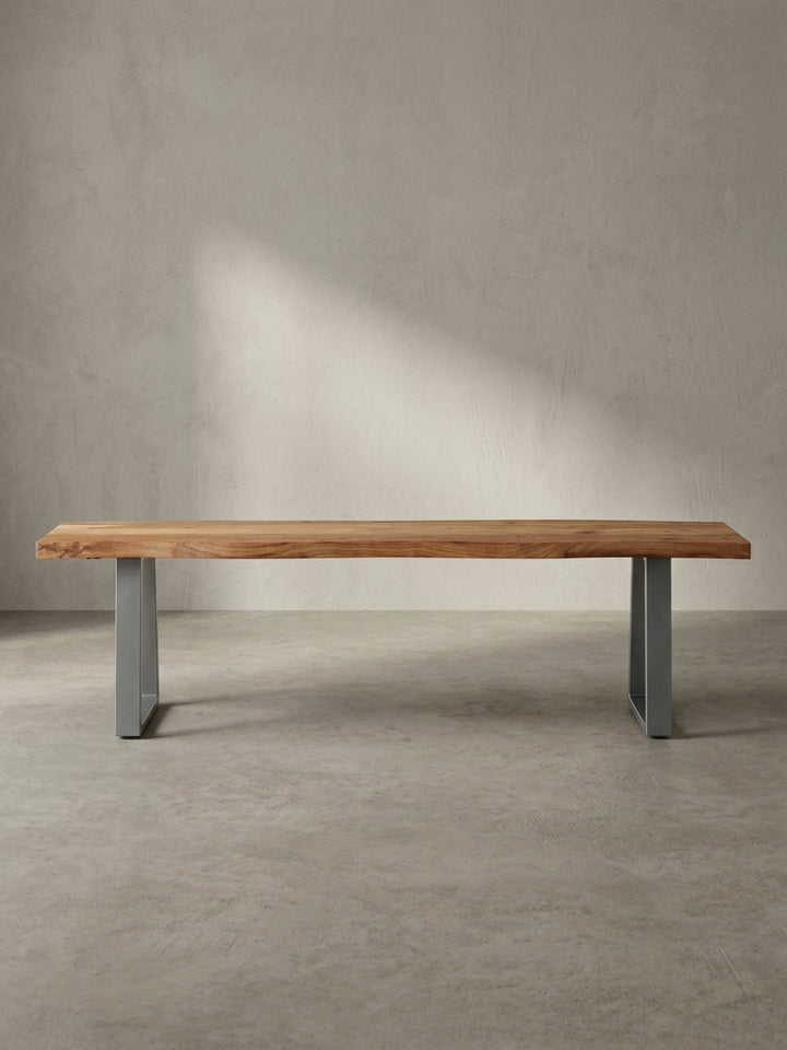 Schrägansicht der modernen Küchenbank aus massivem Akazienholz, die die Tiefe der 3,5 cm starken Sitzplatte und das industrielle Design der Metallkufen zeigt._