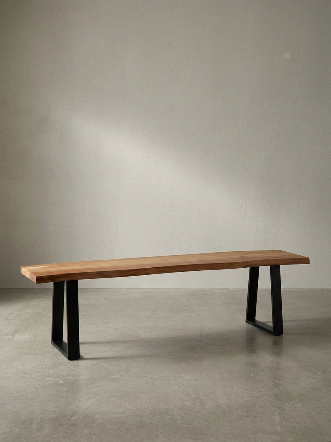 Frontansicht der 140 cm langen Esszimmerbank aus Akazie Massivholz mit charakteristischer Baumkante und schwarzen Trapezbeinen._