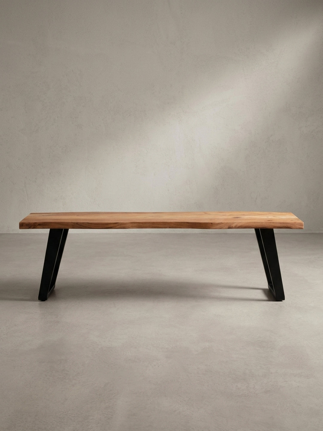 Die Esszimmerbank aus Holz mit markanter Baumkante in der 3/4-Ansicht, die die Tiefe der 40 cm breiten Sitzfläche und die stabilen Metallbeine zeigt._