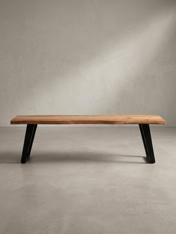 Die Esszimmerbank aus Holz mit markanter Baumkante in der 3/4-Ansicht, die die Tiefe der 40 cm breiten Sitzfläche und die stabilen Metallbeine zeigt._