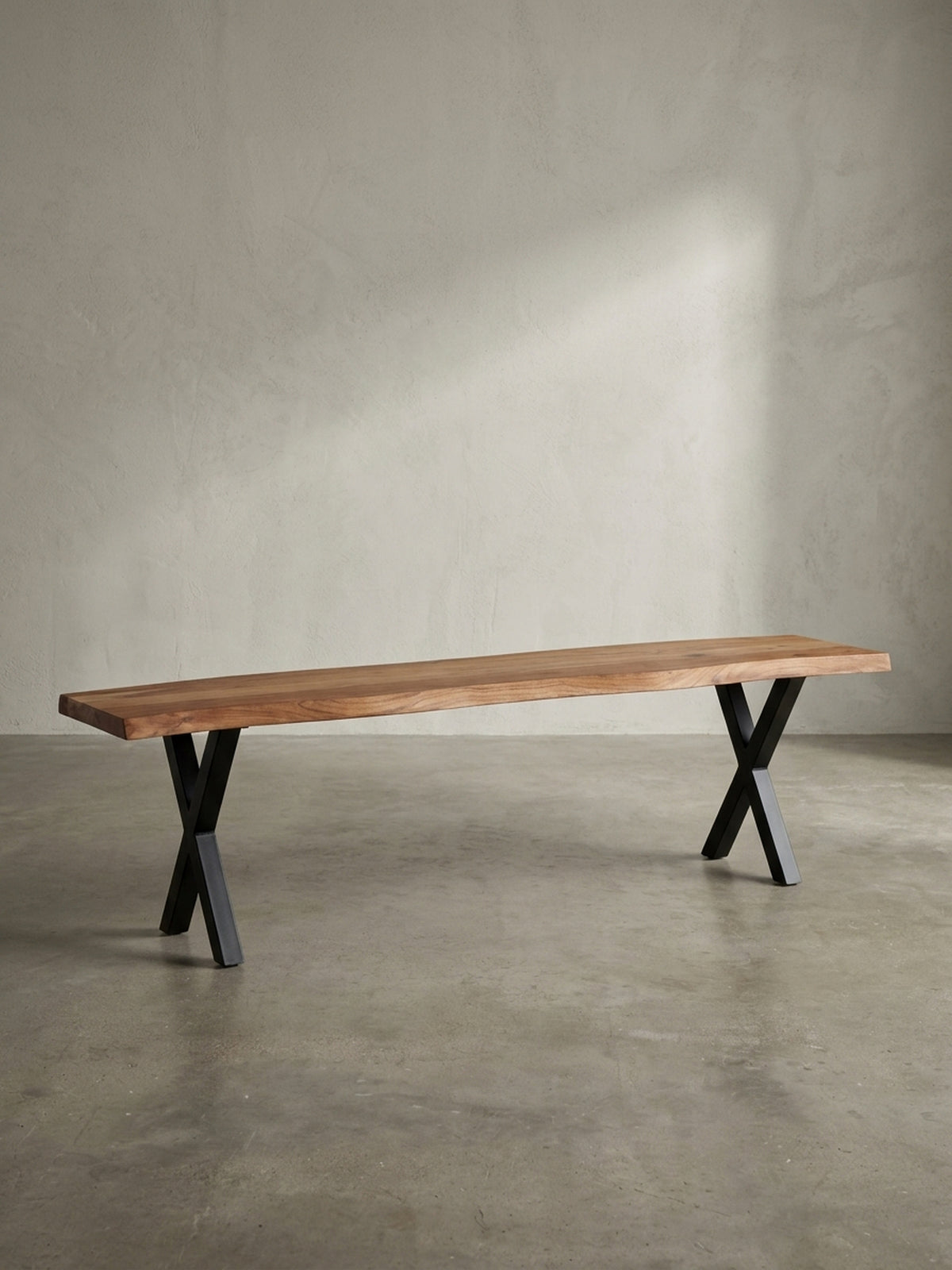 Freigestellte Ansicht der 120 cm langen Sitzbank aus Akazienholz mit schwarzen Metallbeinen in X-Form vor weißem Hintergrund._