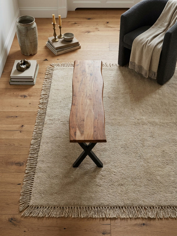 Draufsicht auf eine moderne Essgruppe mit einer 140 cm langen Holzbank aus Akazie und schwarzen Stühlen um einen massiven Esstisch._