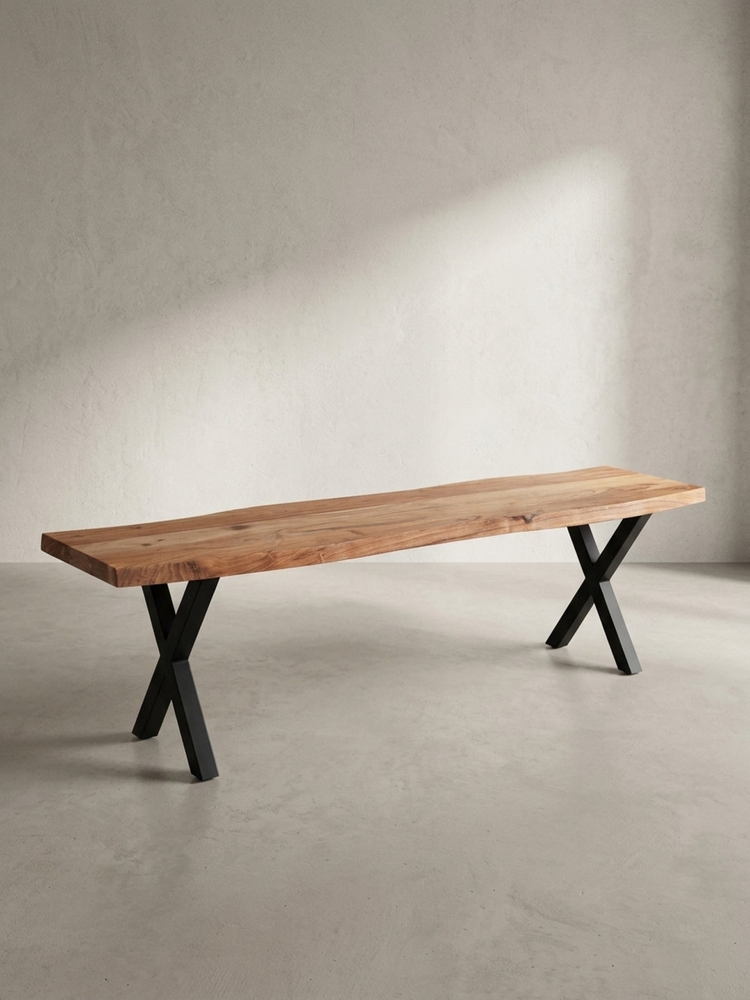 Dreiviertelansicht der 160 cm langen Holzbank, die die Tiefe der massiven Akazienholzplatte und die robuste Konstruktion der X-förmigen Beine zeigt._