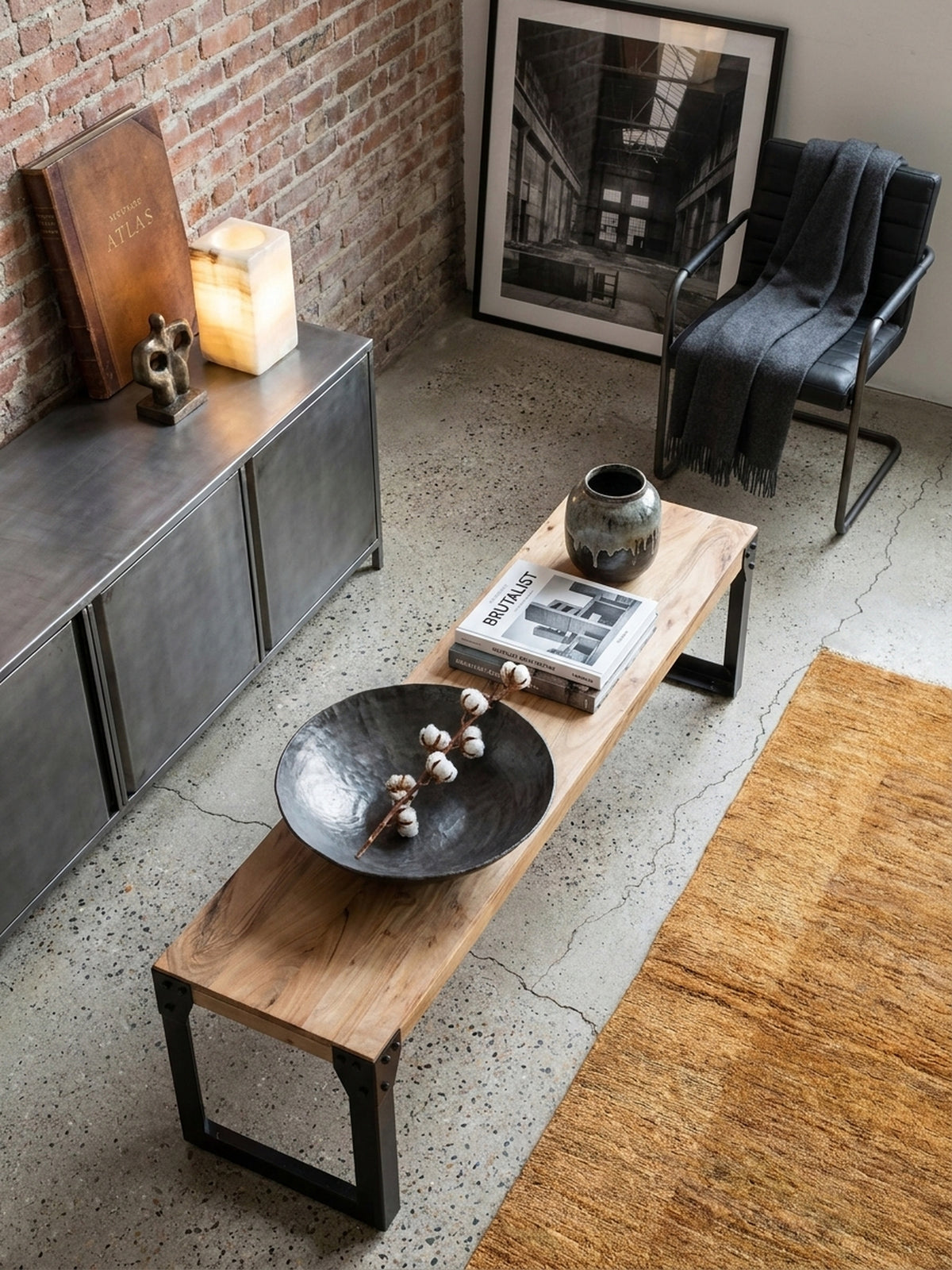 Essbank im Industrial Style von oben betrachtet, positioniert auf einem Fischgrät-Teppich neben einem Esstisch aus Holz._