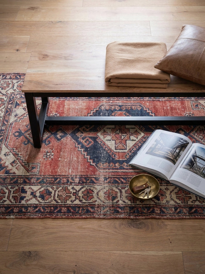Draufsicht auf die massive Holzbank am Esstisch, arrangiert auf einem Vintage-Kilim-Teppich, zeigt die Sitzordnung im offenen Essbereich eines Lofts._