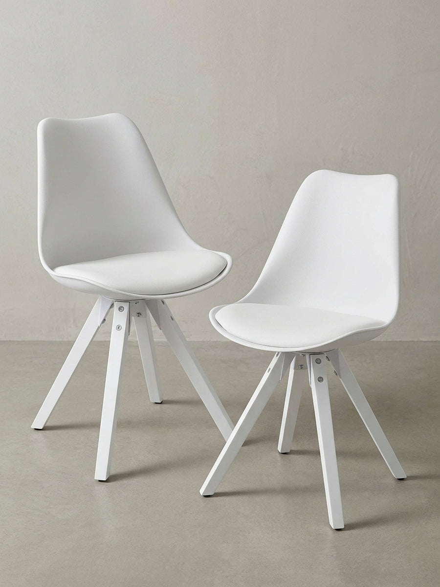Skandinavischer Polsterstuhl in Weiß, 3/4-Ansicht, die die ergonomisch geformte Kunststoff-Sitzschale und die stabilen, weiß lackierten Holzbeine zeigt._
