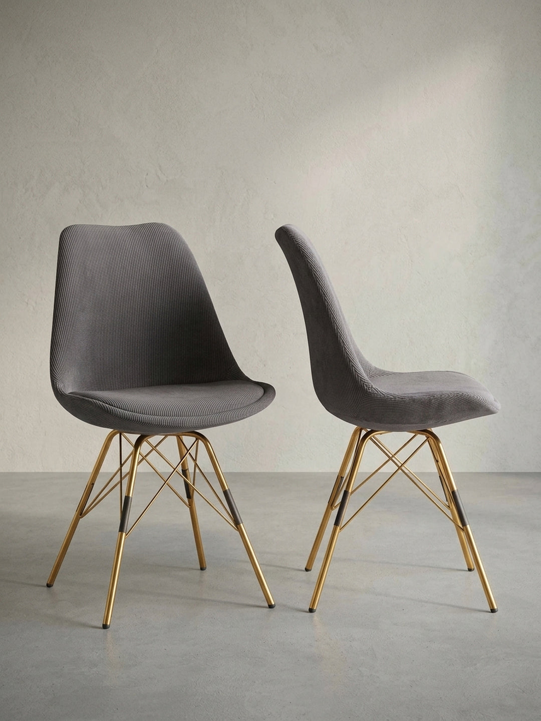 Frontalansicht des ergonomischen Esszimmerstuhls in Anthrazit mit geschwungener Sitzschale und goldenen Beinen vor einem weißen Hintergrund._