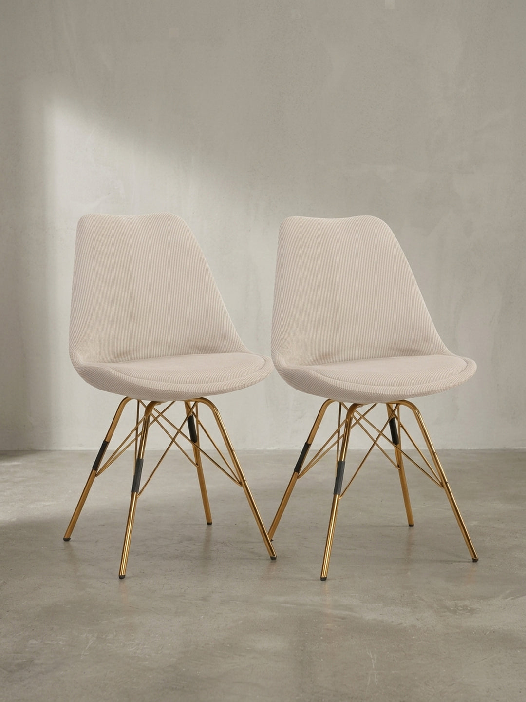 Skandinavischer Esszimmerstuhl mit beiger Cord-Sitzschale und elegantem goldfarben lackiertem Eisengestell freigestellt vor weißem Hintergrund_