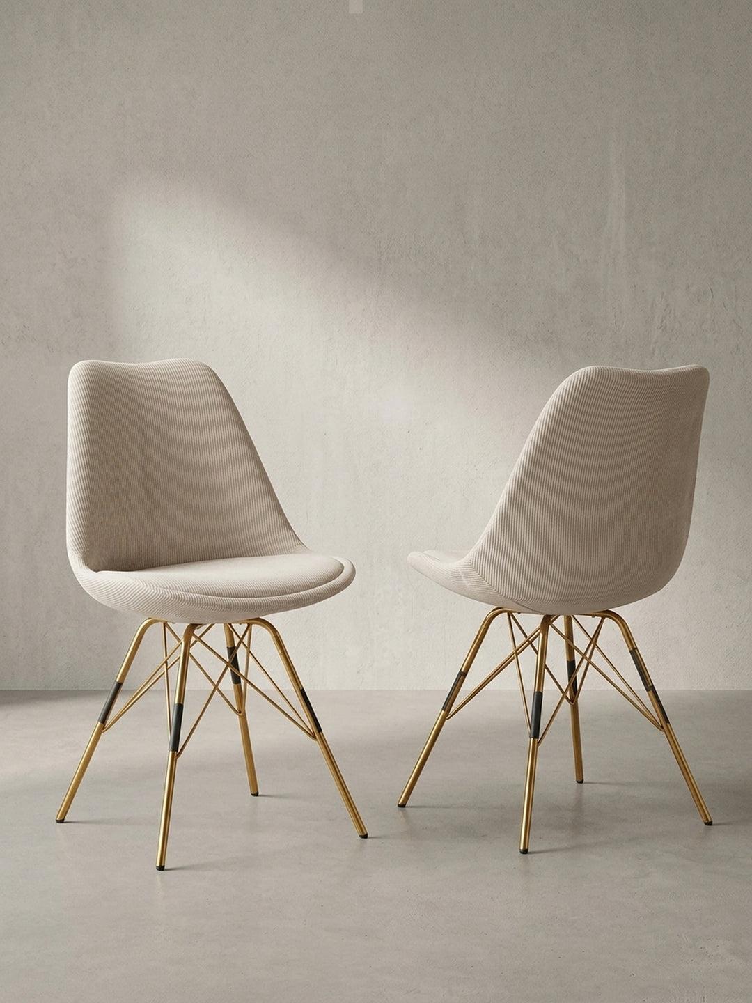 Halbprofil eines beigen Küchenstuhls aus Cordstoff zur Veranschaulichung der ergonomischen Schalenform und des überkreuzten Metallgestells_