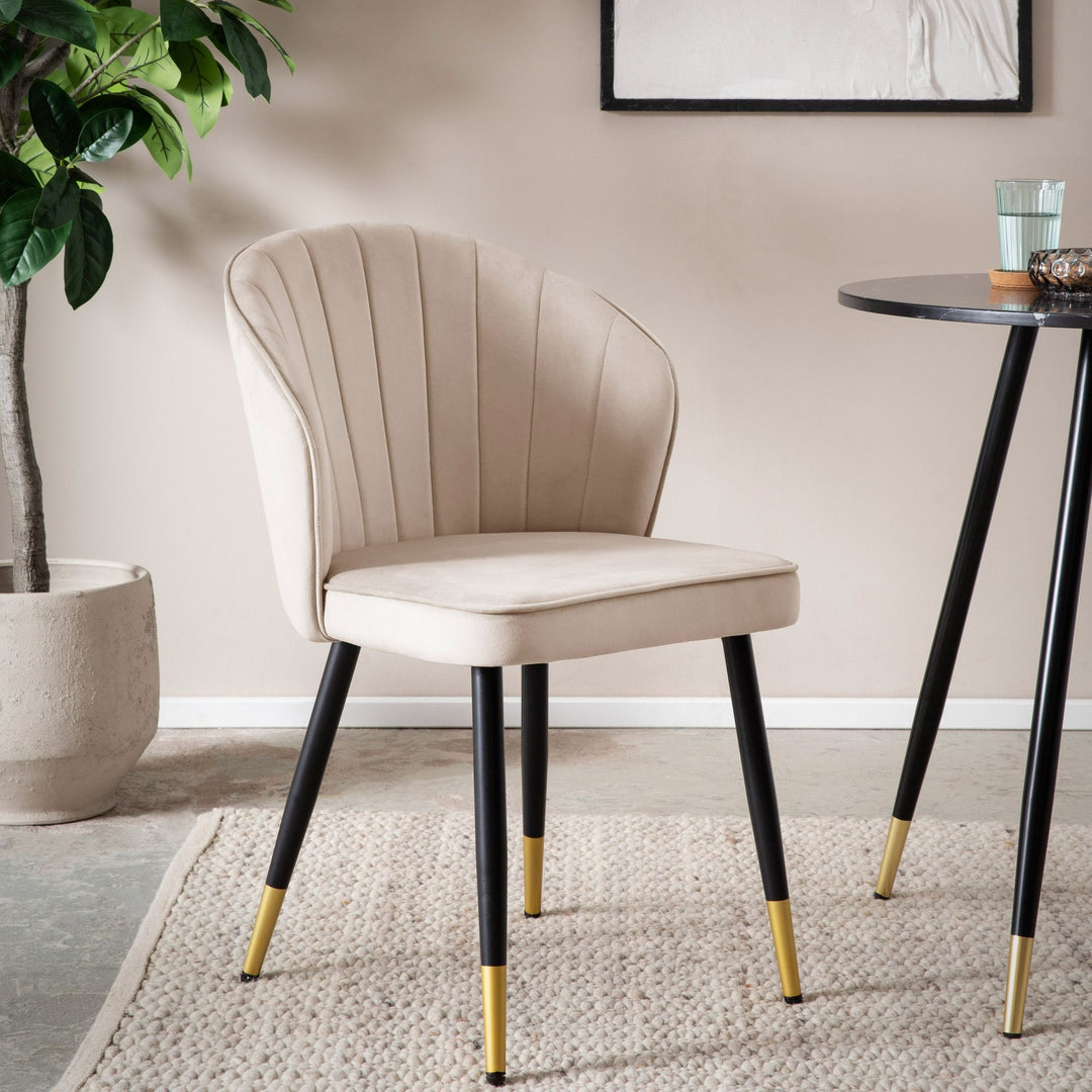 Beiger Polsterstuhl aus Samt mit schwarzem Metallgestell und goldfarbenen Füßen _
