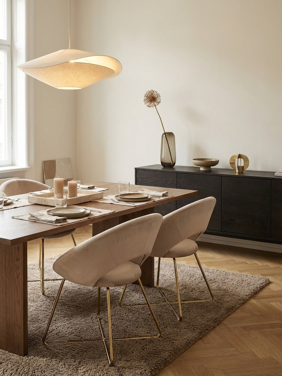 Eleganter Esszimmerstuhl in Beige-Samt mit goldenen Beinen in einem lichtdurchfluteten, modernen Esszimmer, kombiniert mit einem Marmortisch und Holzboden._