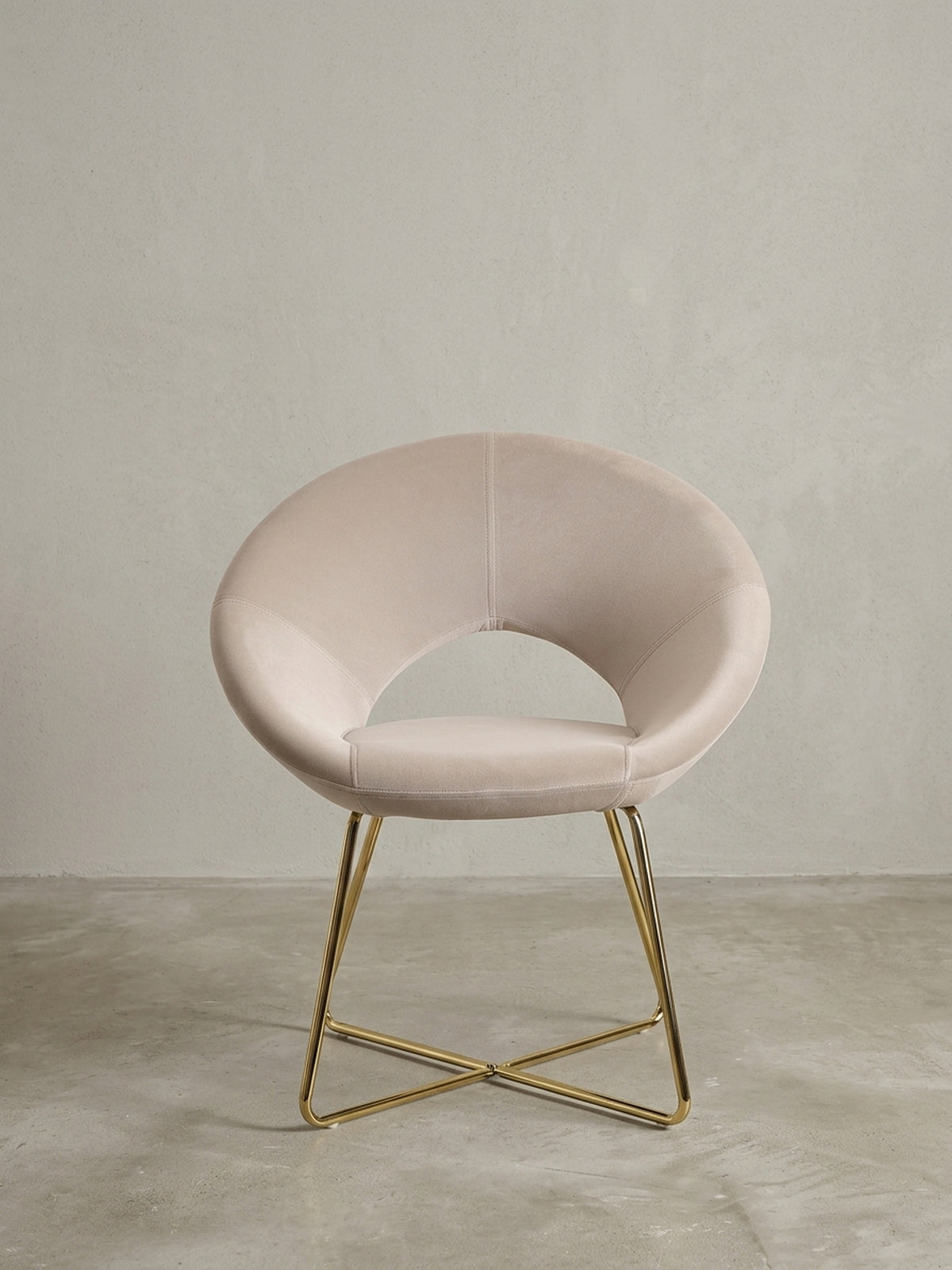 Esszimmerstuhl in Samt Beige aus der Dreiviertelperspektive, zeigt die geschwungene Sitzschale und die elegant gekreuzten goldenen Stuhlbeine.