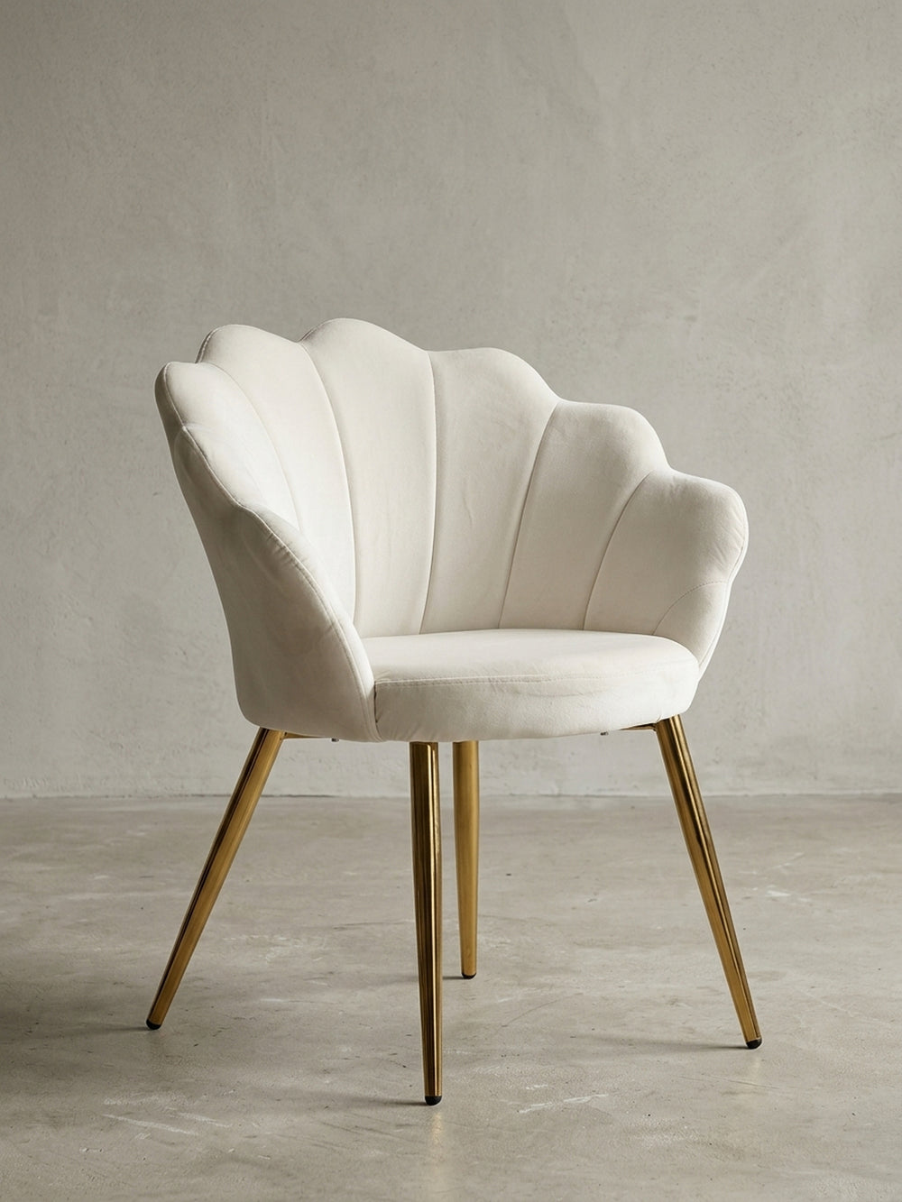 Frontansicht des gepolsterten Esszimmerstuhls aus Samt in Weiß mit seiner charakteristischen Tulpen-Rückenlehne und den eleganten, goldfarbenen Metallbeinen._