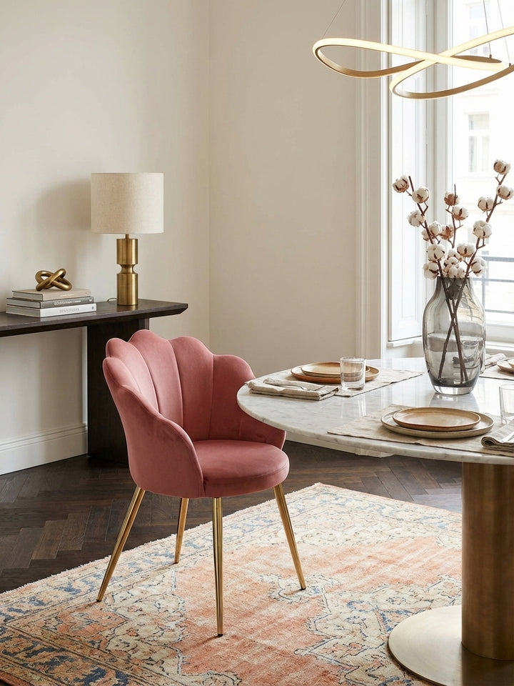 Eleganter Esszimmerstuhl in Altrosa Samt mit goldenen Beinen, stilvoll platziert an einem Marmortisch in einem luxuriösen Esszimmer mit Parkettboden._