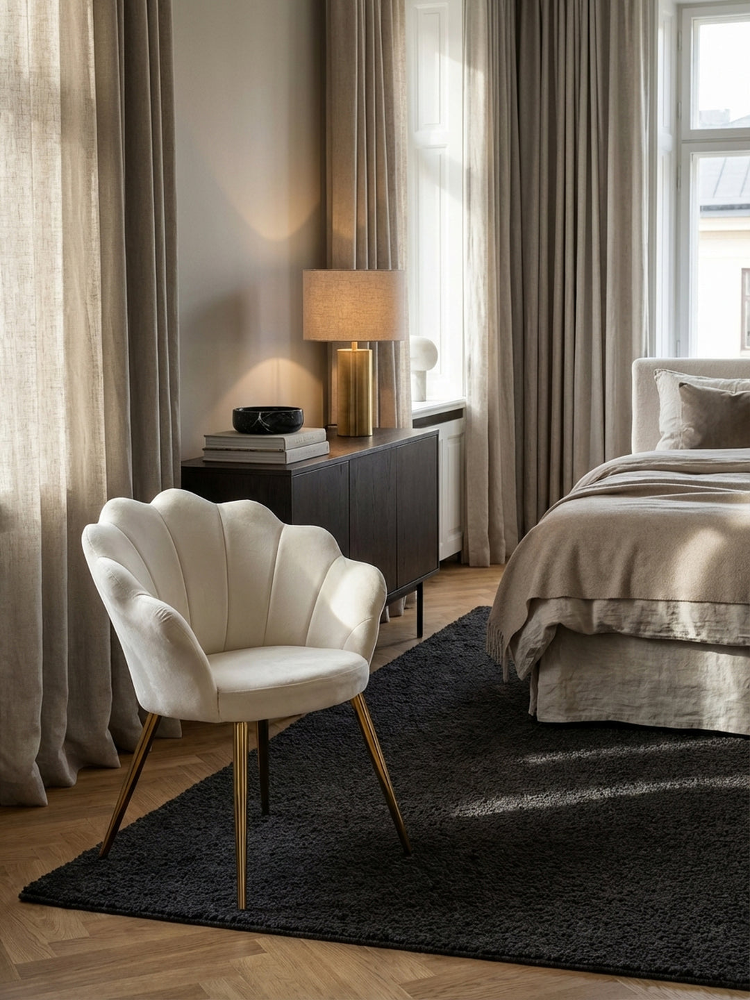 Draufsicht auf ein Esszimmer-Ensemble mit vier cremefarbenen Tulpenstühlen aus Samt, die symmetrisch um einen dunklen Esstisch auf einem texturierten Teppich arrangiert sind._