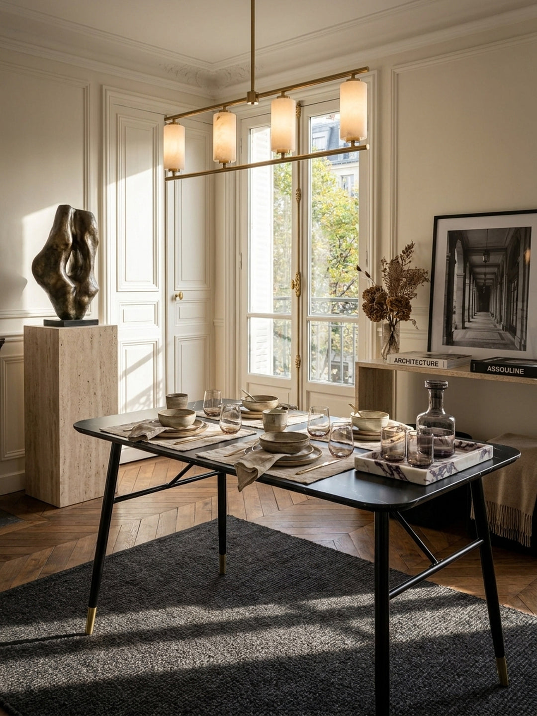 Großzügiges Pariser Esszimmer mit kompaktem Esstisch in schwarzer Marmor-Optik 120x60 cm und goldenen Akzenten auf dunklem Chevron-Parkett unter einer Alabaster-Pendelleuchte_