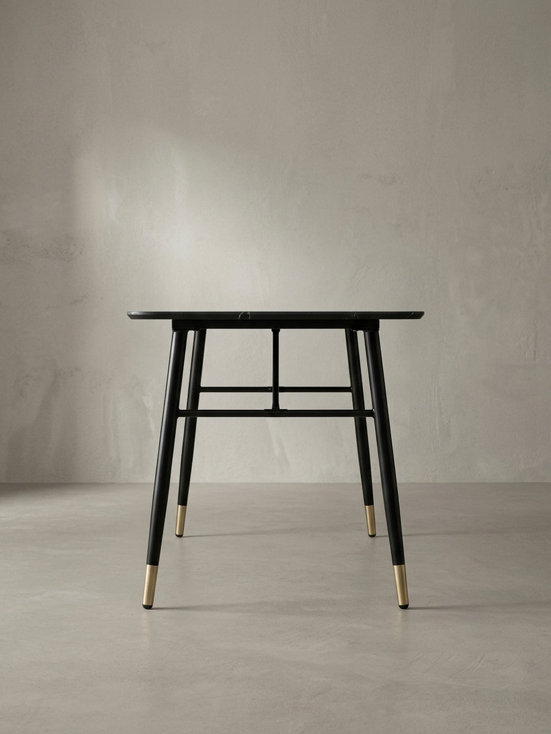 Seitliche Perspektive des eleganten Speisetisches 140x80x76 cm bei der die leicht ausgestellten schwarzen Eisenbeine und das schmale Profil der Tischplatte gut sichtbar sind._