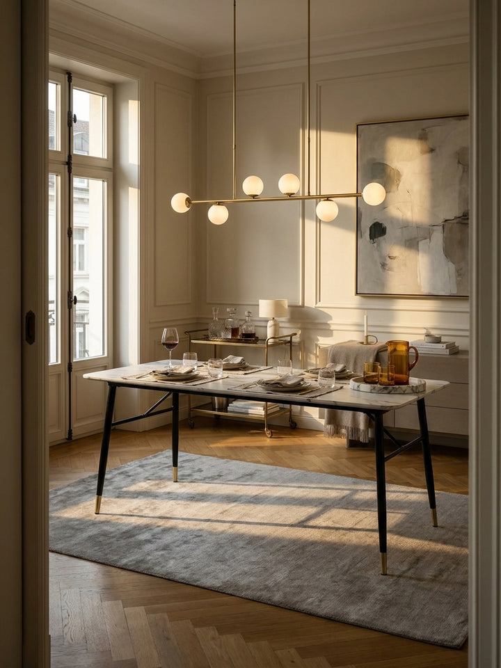 Eleganter Esszimmertisch 160x80 cm in weißer Marmor-Optik mit schwarzen Metallbeinen im stilvoll eingerichteten Pariser Apartment mit klassischer Wandvertäfelung_
