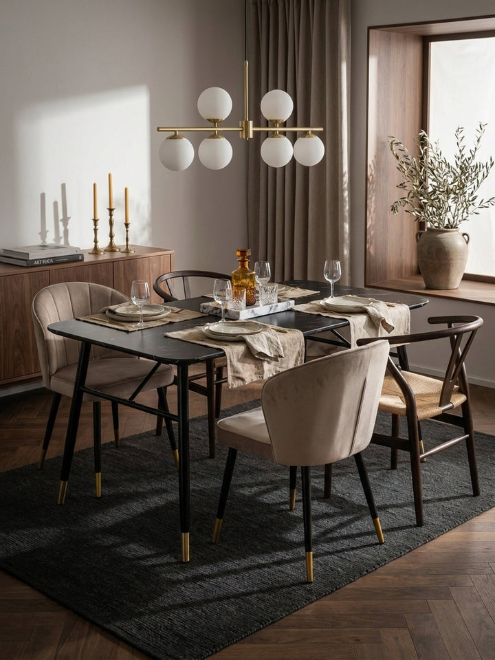 Moderner Esszimmertisch mit filigranen Eisenbeinen kombiniert mit beigen Polsterstühlen vor einer cremeweißen Wand im Haussmann-Stil_