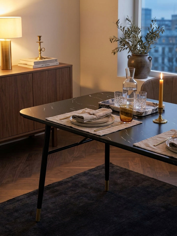 Gedeckter Speisetisch in elegantem Schwarz auf einem weichen Wollteppich arrangiert mit stilvoller Dekoration für ein gemütliches Dinner_