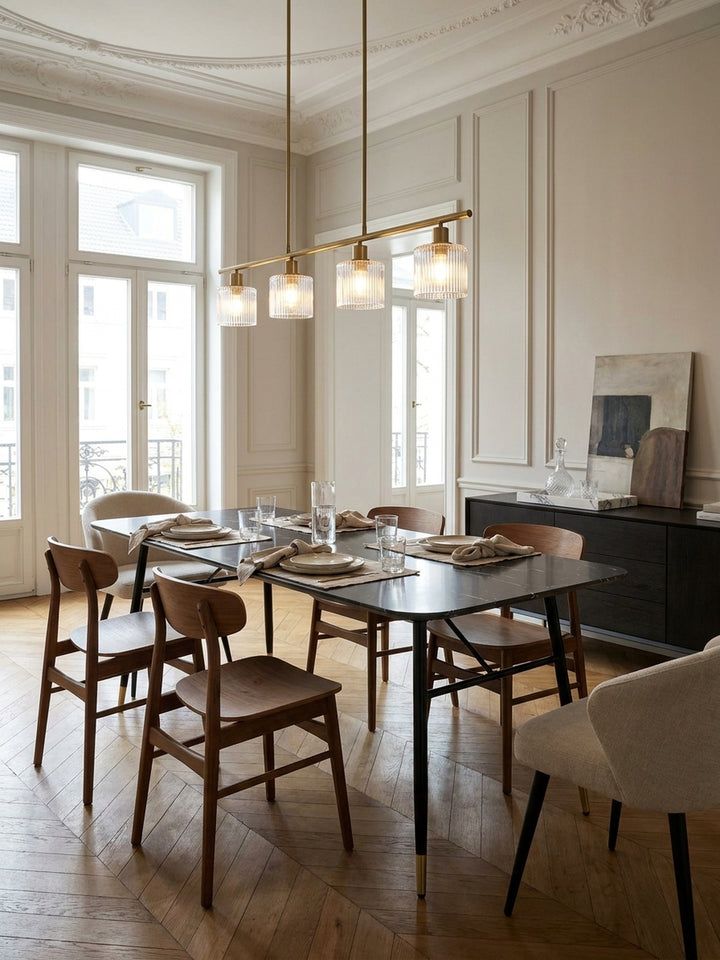 Rechteckiger Speisetisch mit schwarzen Metallbeinen kombiniert mit eleganten grauen Samtstühlen auf Eichenparkett._