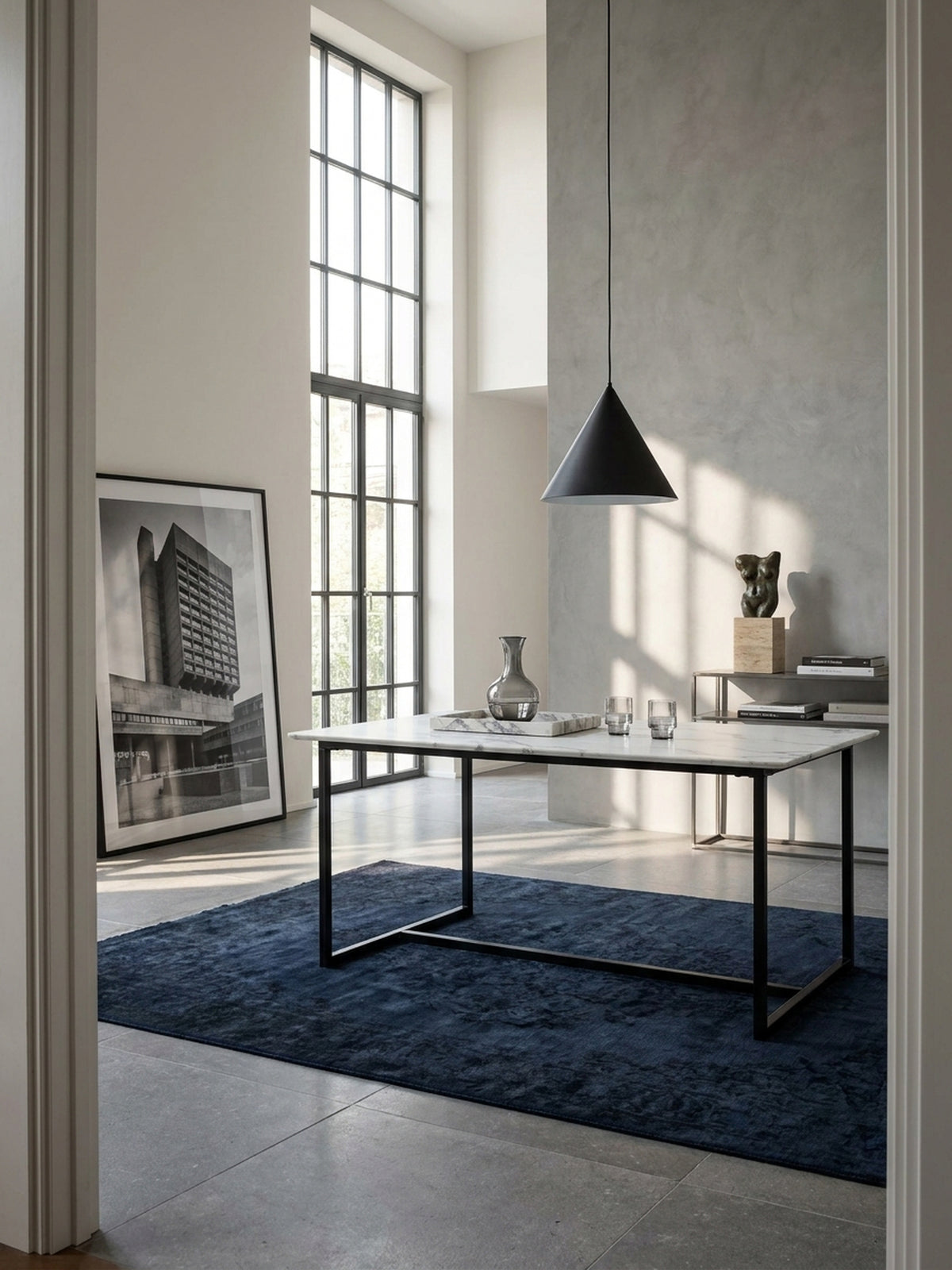 Moderner Esstisch in weißer Marmor-Optik 160x80 cm mit schwarzem Metallgestell freistehend im minimalistischen Esszimmer auf edlem Kalksteinboden._