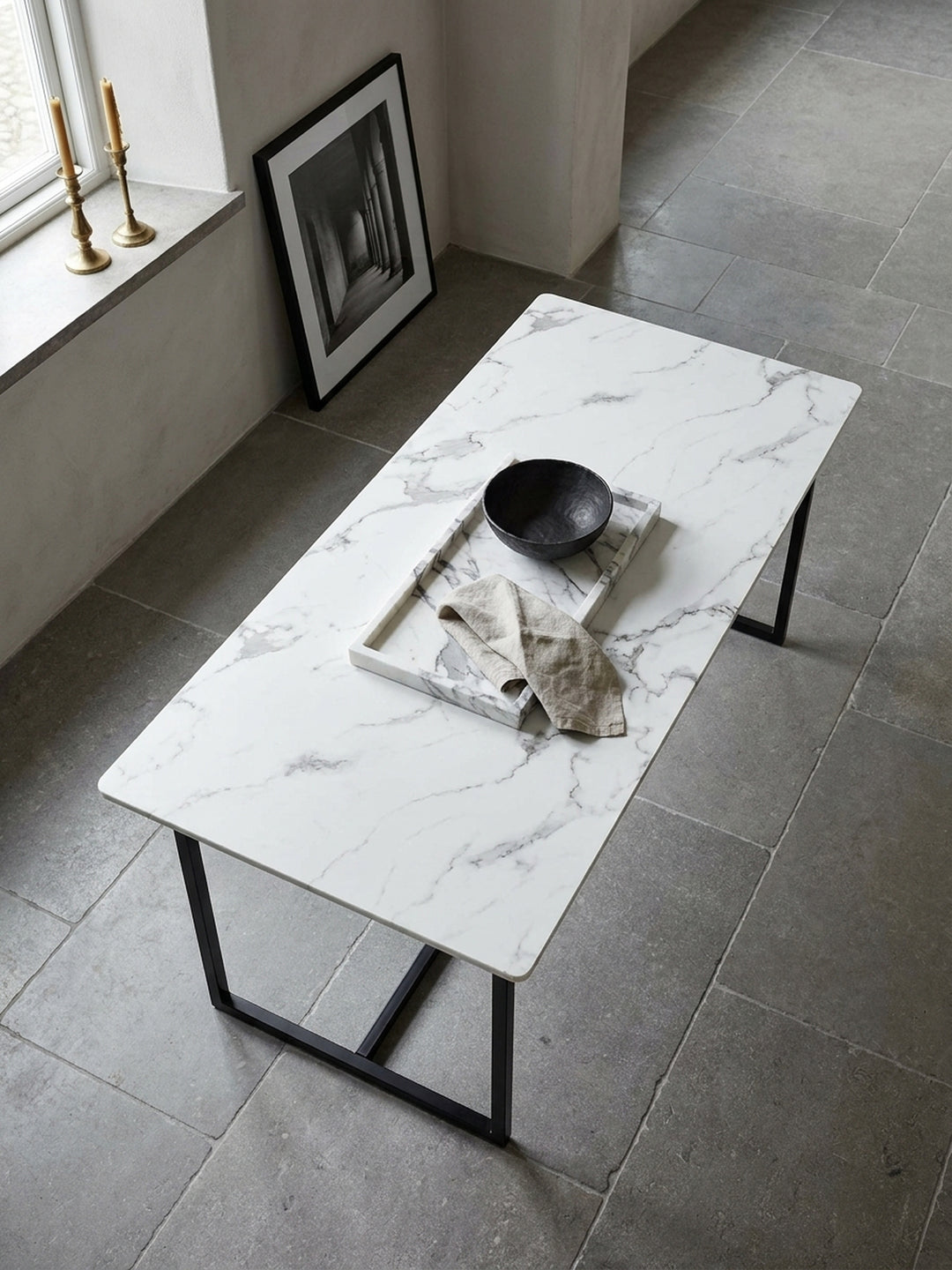 Blick von oben auf den modernen Speisetisch mit glänzendem Marmor-Dekor und Eisengestell umgeben von Designer-Stühlen in einem weitläufigen hellen Raum_