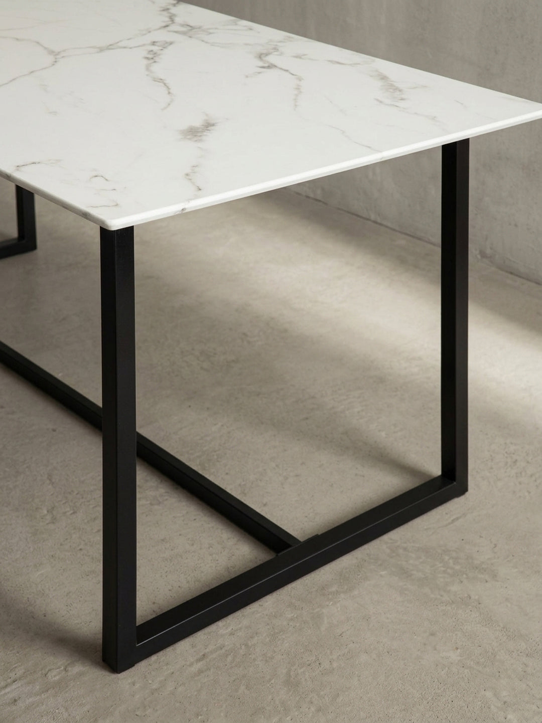 Alternative Perspektive des 200x90 cm großen Esszimmertisches in Weiß-Marmor fokussiert auf die klaren architektonischen Linien des Unterbaus_