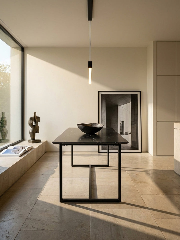 Schwarzer Esszimmertisch 200x90 cm in edler Marmoroptik mit Metallgestell im minimalistischen Wohnbereich auf geschliffenem Kalksteinboden_