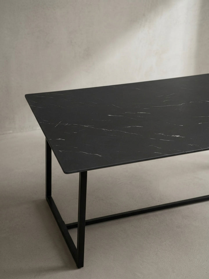 Minimalistischer Tisch für das Esszimmer 200x90 cm mit leicht glänzender schwarzer Oberfläche leicht schräg von oben freigestellt präsentiert_