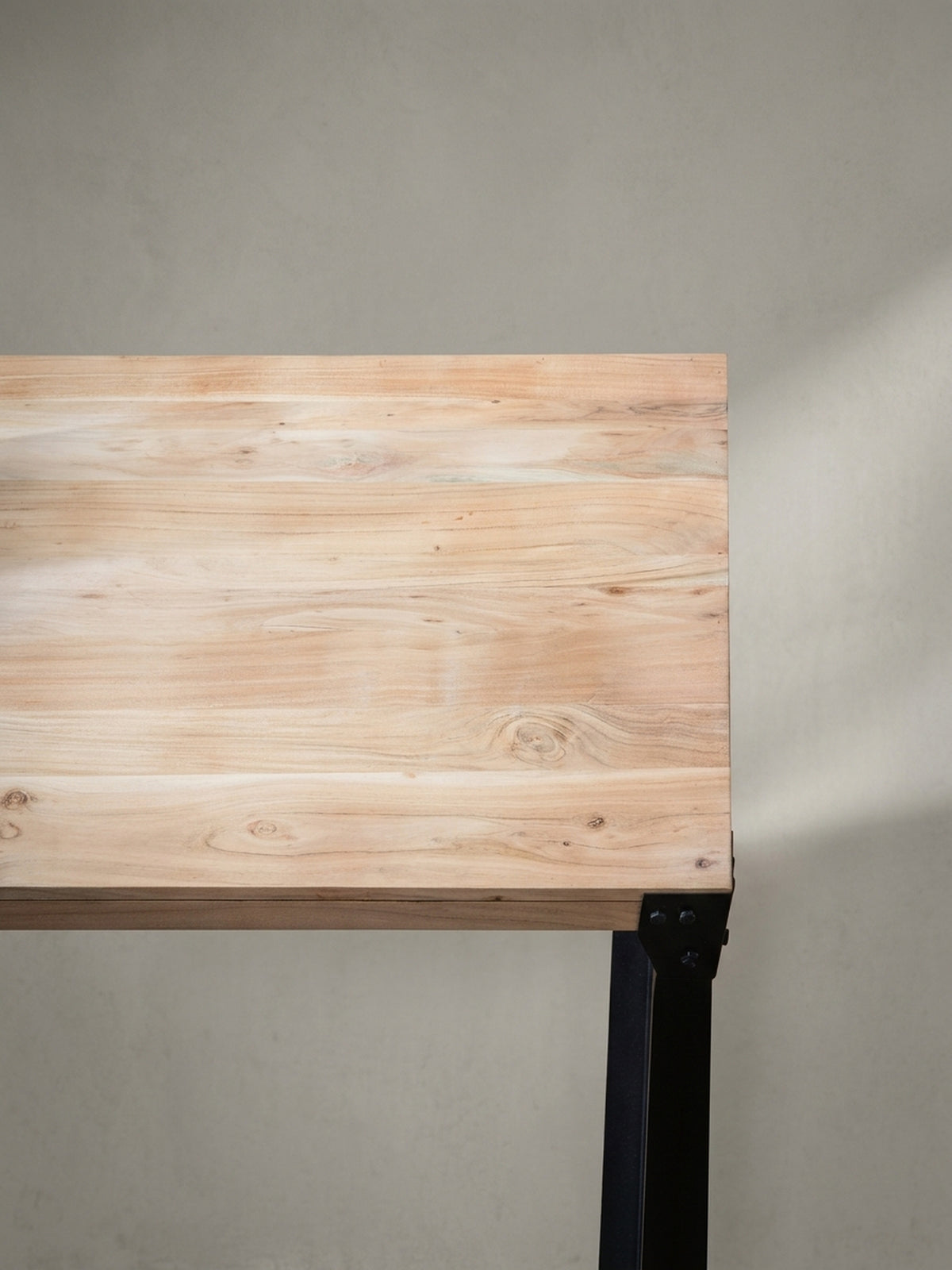 Nahaufnahme eines schwarzen Eckbeschlags mit Nieten am Esstisch, ein charakteristisches Detail des authentischen Industrial-Looks für das Esszimmer.