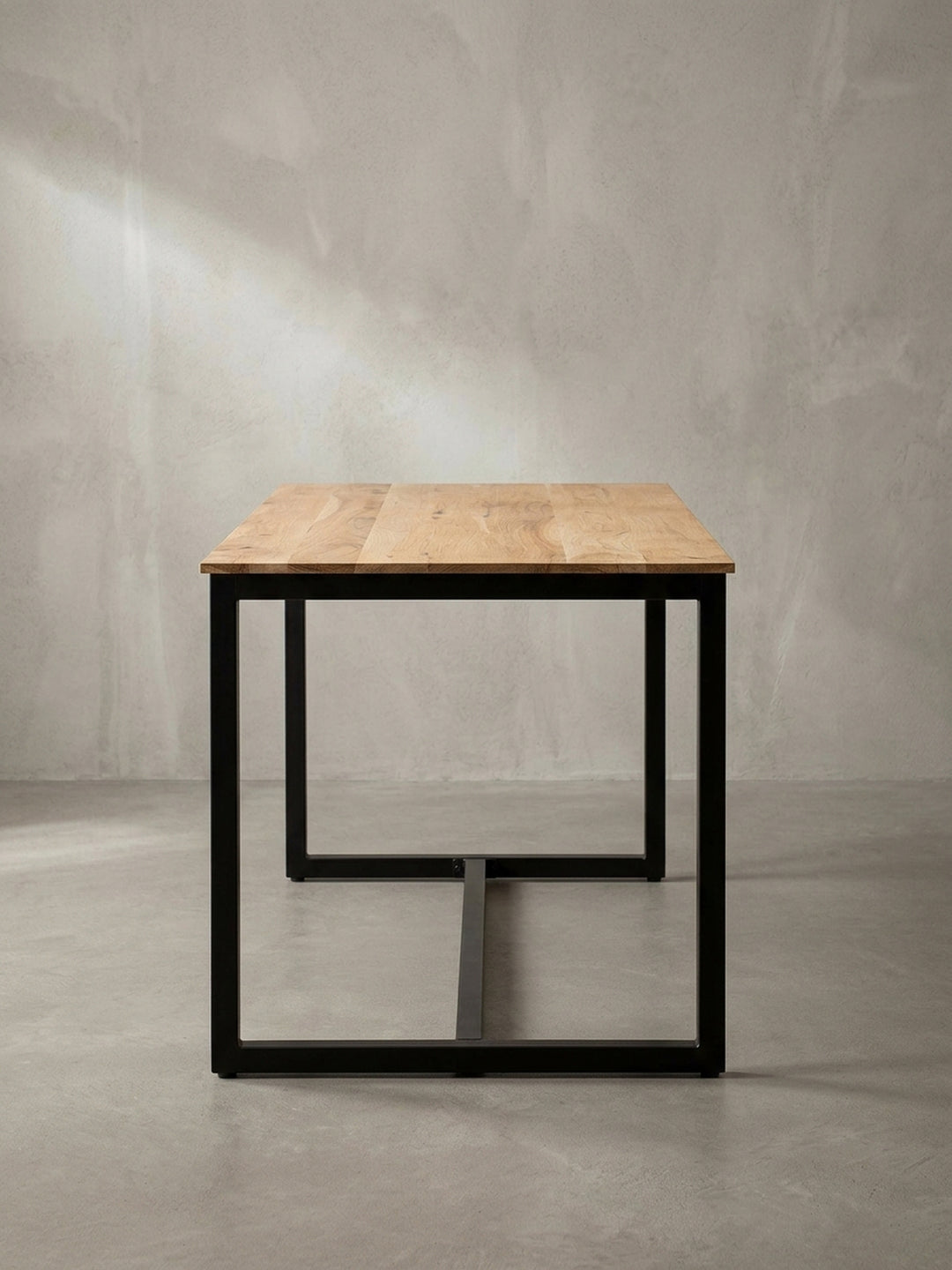 Gesamtübersicht des hochwertigen Esszimmertisches, dessen markante Akazienholzmaserung und schwarze eiserne Kufenbeine ein harmonisches und zeitloses Industrial-Design formen._