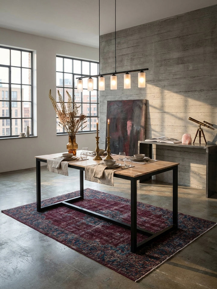 Großzügiges Loft-Esszimmer mit dem industriellen Esstisch aus massivem Akazienholz auf poliertem Betonboden unter einer linearen Pendelleuchte_