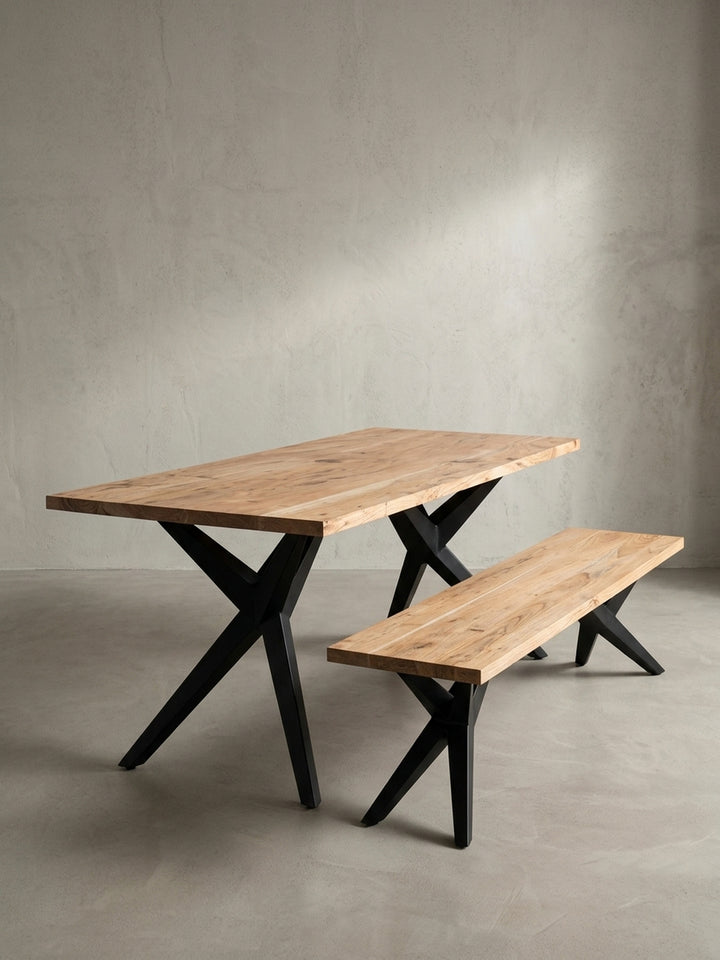 Schräge 3/4-Ansicht des Loft-Esstisches, die das Zusammenspiel der natürlichen Holzplatte und der geometrischen schwarzen Eisenbeine betont._
